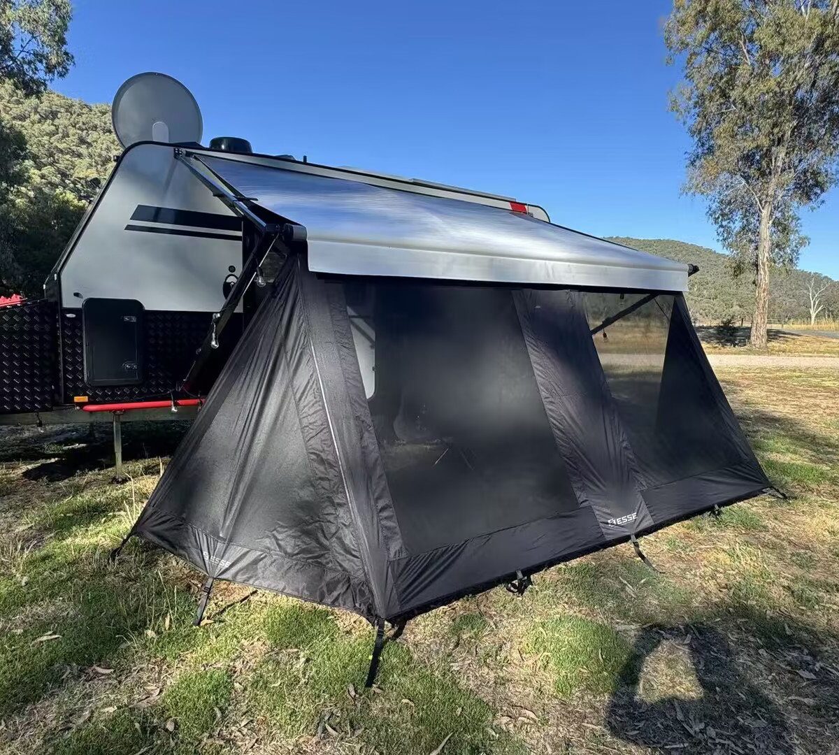 Triangular privacy wall mounted on a caravan awning rail
