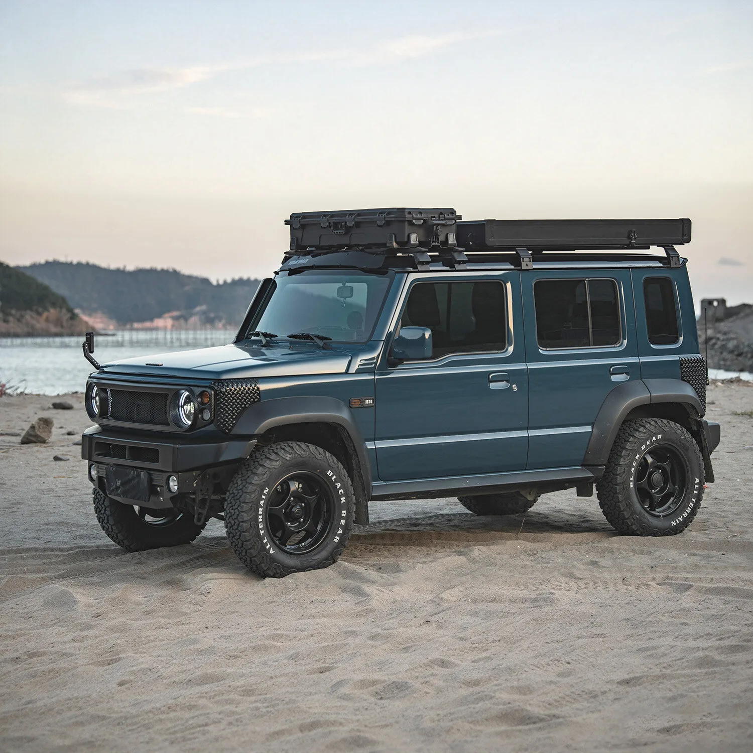 Light Clam Shell RTT Fold 128 closed on a Suzuki Jimny on the beach